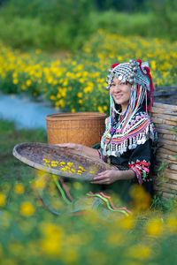 Woman wearing hat while standing against yellow wall