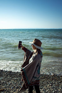 Man standing on beach against clear sky