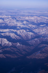 Aerial view of snowcapped mountains against sky