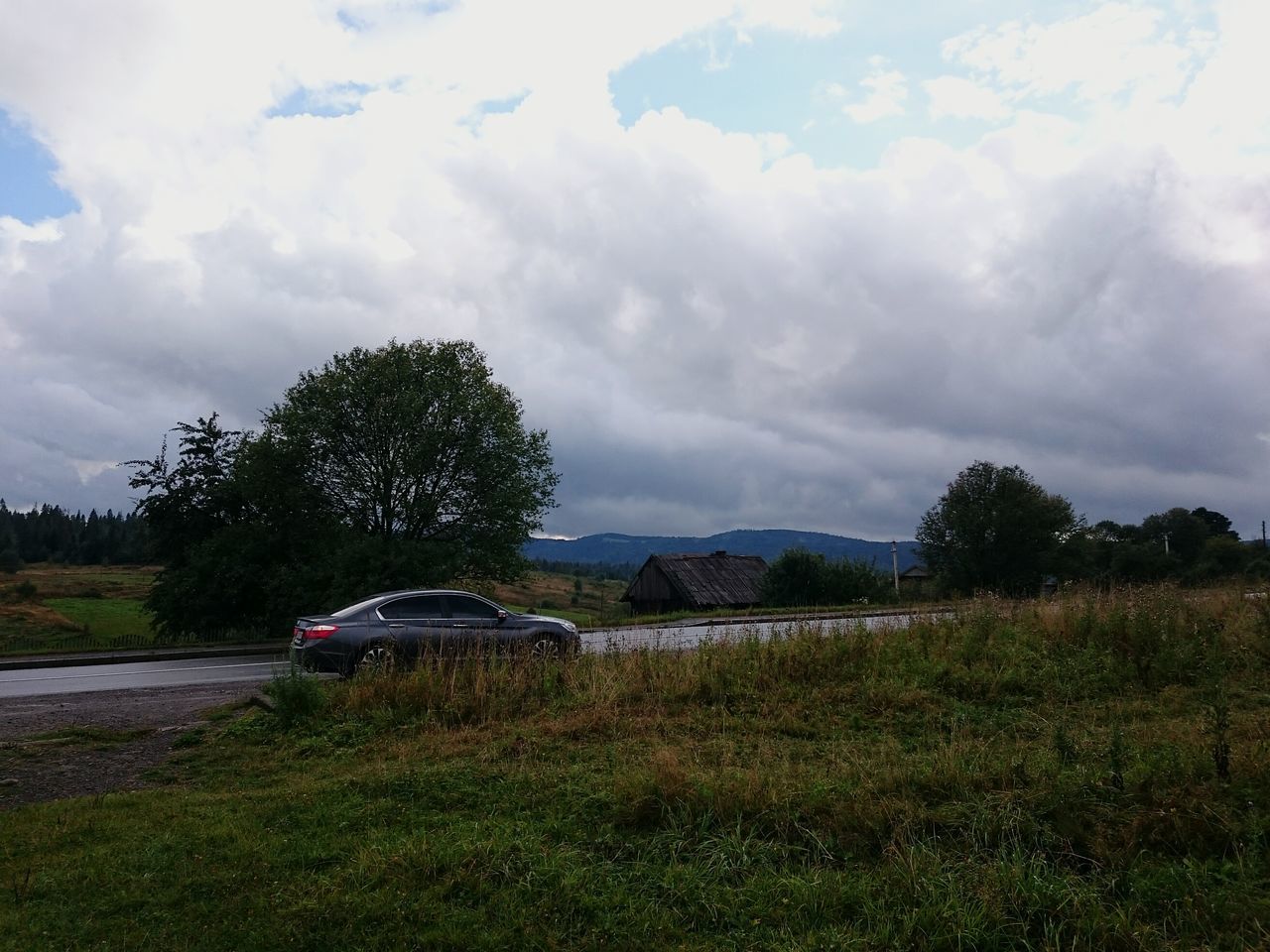 sky, cloud - sky, transportation, tree, grass, cloudy, tranquility, cloud, tranquil scene, landscape, mode of transport, land vehicle, nature, field, car, scenics, beauty in nature, growth, plant, road