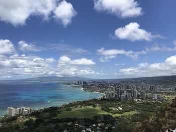 High angle view of city by sea against sky