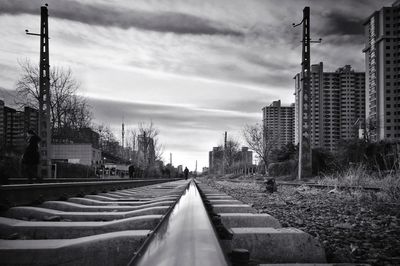 Railroad tracks in city against sky