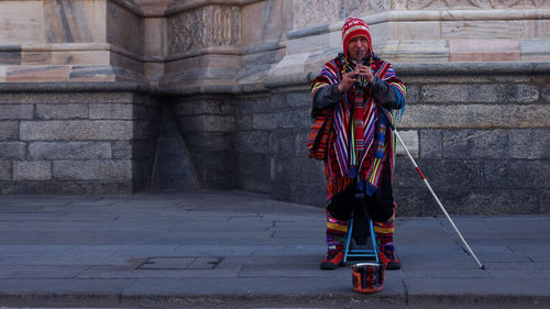 Portrait of street musician playing musical equipment on sidewalk