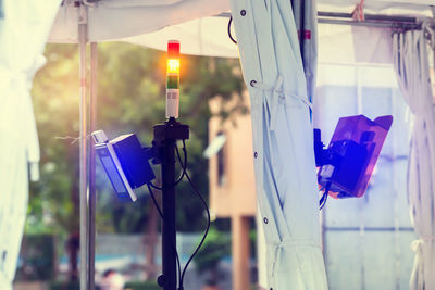 Close-up of lighting equipment hanging on glass window