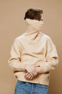 Rear view of woman standing against yellow background