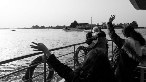 People on boat against clear sky