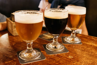 Beer glasses on wooden table at bar