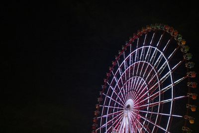 Low angle view of illuminated ferris wheel against sky at night