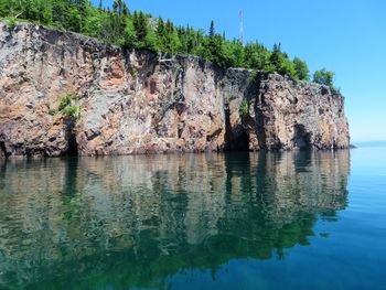 Rock formations by sea against sky