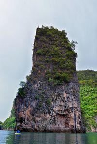 Rock formations by sea against sky