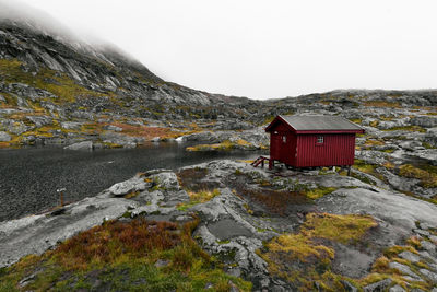 Remote isolated munkebu cabin with rocky wet landscape on rainy day in winter lofoten islands