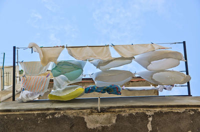 Low angle view of clothes drying against sky