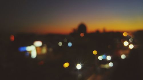 Defocused image of illuminated lights at sunset