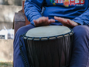 Midsection of man playing drum