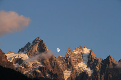 Low angle view of snowcapped mountains against sky