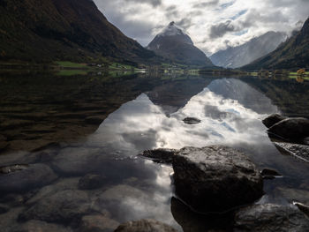 Scenic view of lake by mountains against sky