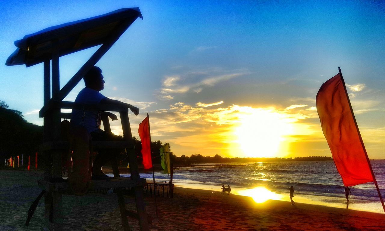 sea, sunset, sky, water, horizon over water, sun, beach, sunlight, transportation, orange color, scenics, flag, shore, beauty in nature, built structure, nature, nautical vessel, tranquility, tranquil scene, outdoors