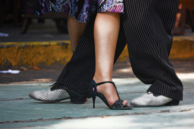 Low section of woman standing on footpath