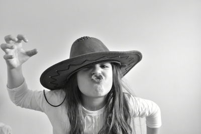 Portrait of an young girl wearing hat against white background