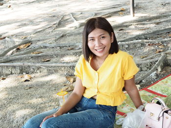 Portrait of a smiling young woman sitting outdoors