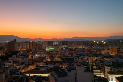 High angle view of illuminated buildings against sky during sunset