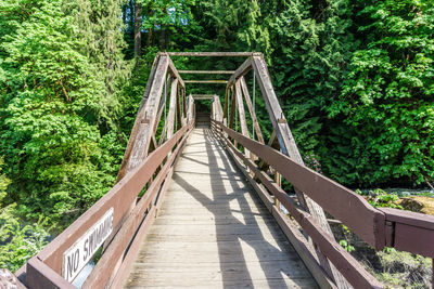 Footbridge amidst trees in forest at tumwater falls in washington state.