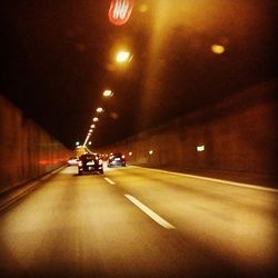 Road passing through illuminated tunnel