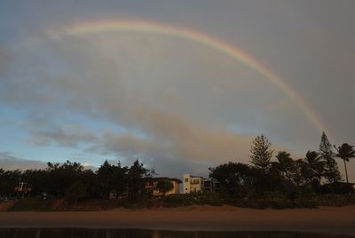 Scenic view of rainbow over buildings against sky