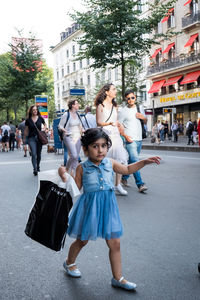 Group of people walking on road in city