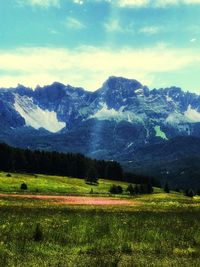 Scenic view of field and mountains against sky