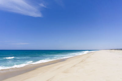 View of calm beach against blue sky