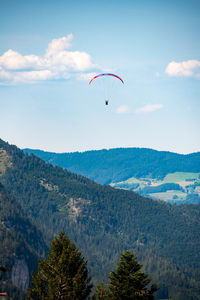Low angle view of person paragliding against sky