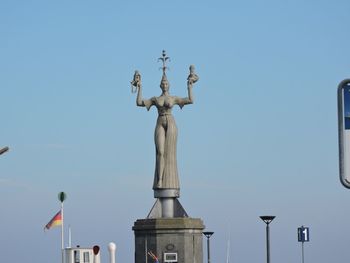 Low angle view of statue against clear blue sky