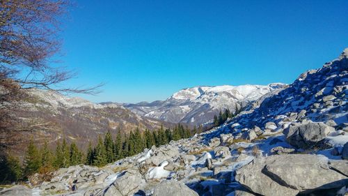 Scenic view of snowcapped mountains against blue sky