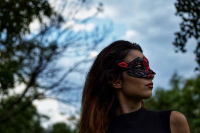 Portrait of young woman wearing sunglasses against trees