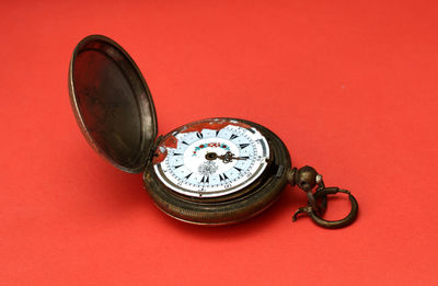 Close-up of antique clock against red background