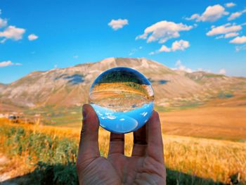 Cropped hand of person holding crystal ball