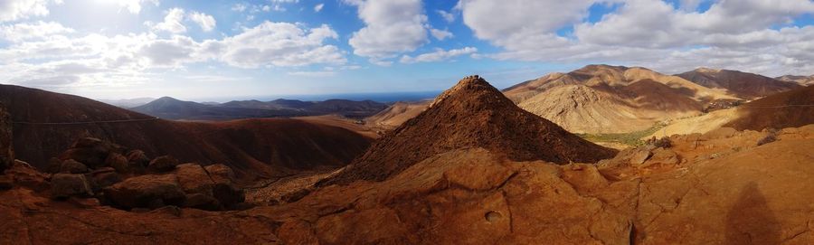 Panoramic view of desert against cloudy sky