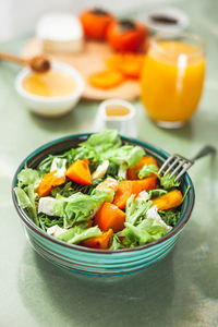 Light sweet and sour salad with persimmon, tangerines and cheese. winter vitamin salad 