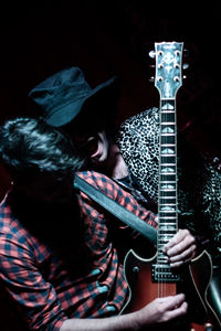 Midsection of man playing guitar