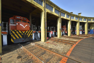 Graffiti on railroad tracks by buildings in city against sky