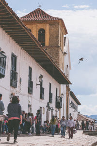 Group of people in city buildings against sky