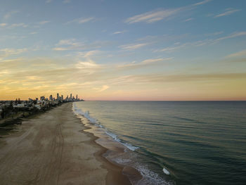 Scenic view of a city facing the sea during sunset