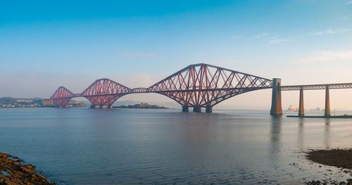 Bridge over calm lake against clear sky