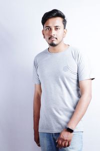 Portrait of young man standing against white background