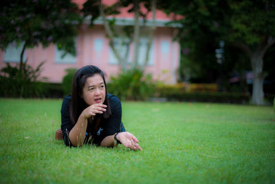 Woman sitting on grass in lawn