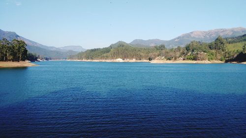 Scenic view of lake against clear blue sky