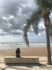 Rear view of man sitting on beach