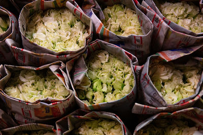 White roses wrapped in newspaper. flower market, bangkok.