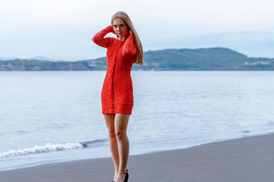 Full length of young woman standing on beach